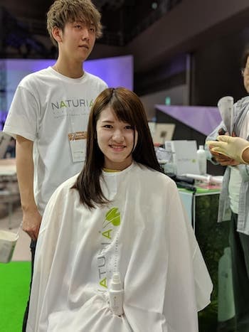 Hair stylist applying keratin on model